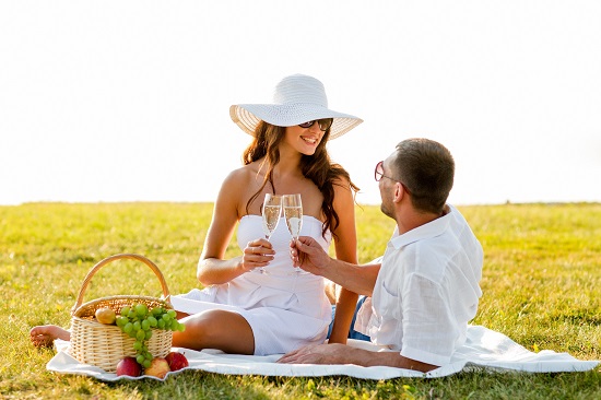 smiling couple drinking champagne on picnic
